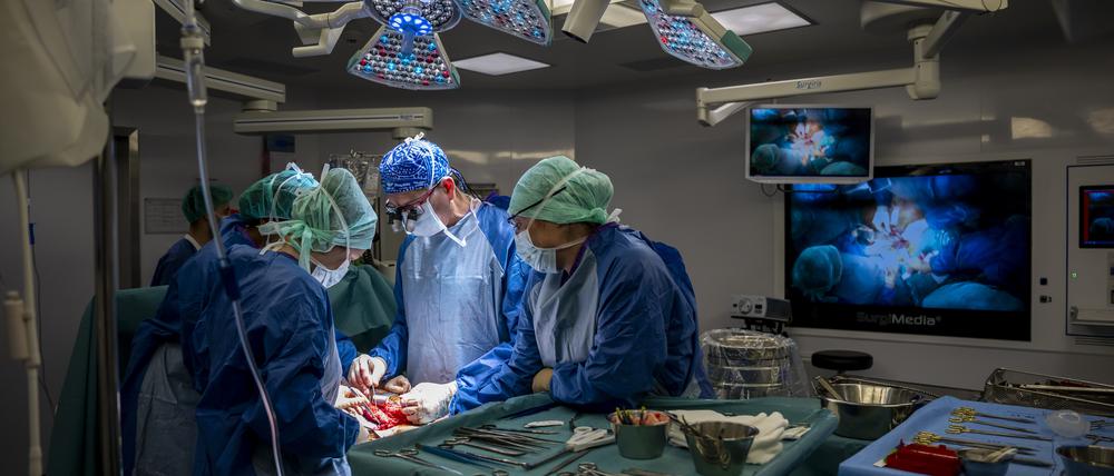 Das Personal eines Operationssaals führt eine Transplantation durch, nachdem es einem Spender eine Niere entnommen hat.