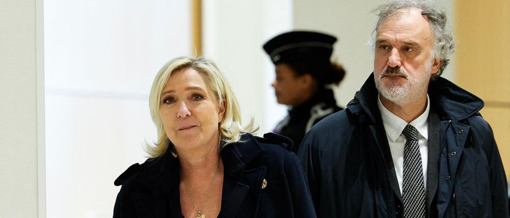 French far-right Rassemblement National (RN) Member of Parliament Marine Le Pen (L) walks with lawyer Rodolphe Bosselut (R) outside the courtroom during a break in the closing arguments hearing of her trial with 24 others for embezzling funds from the European Parliament for the benefit of the far-right party, in Paris on November 13, 2024. (Photo by GEOFFROY VAN DER HASSELT / AFP)