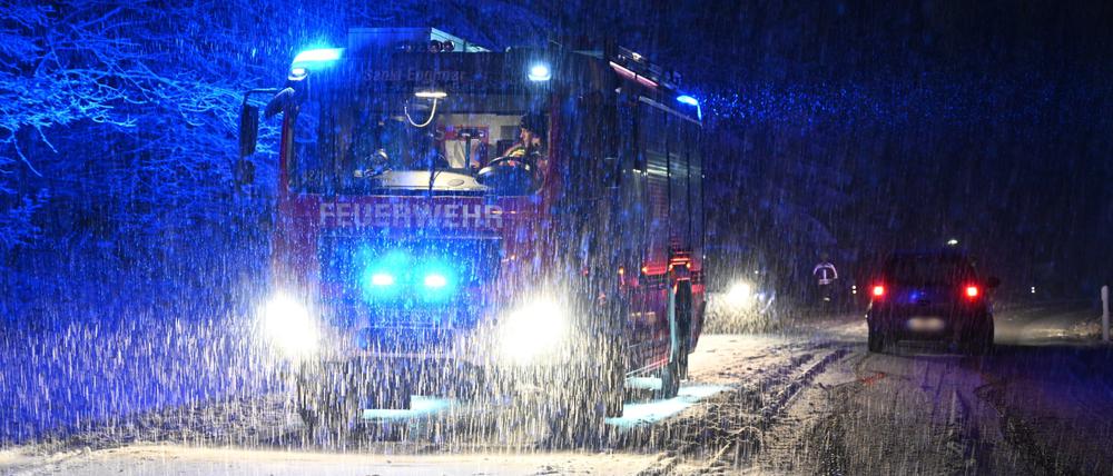 Bei heftigem Schneefall ist die Feuerwehr auf einer Landstraße in Bayern im Einsatz.