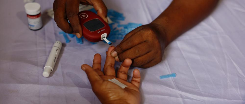 Eine Person erhält einen kostenlosen Blutzuckertest während einer Kampagne zum Weltdiabetestag in Dhaka, Bangladesch.