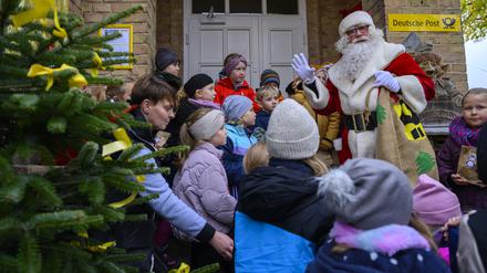 Weihnachtsmann steht mit Kindern vor dem Weihnachtspostamt. Knapp sechs Wochen vor Heiligabend hat der Weihnachtsmann im brandenburgischen Himmelpfort wieder seine Wunschzettel-Filiale eröffnet.