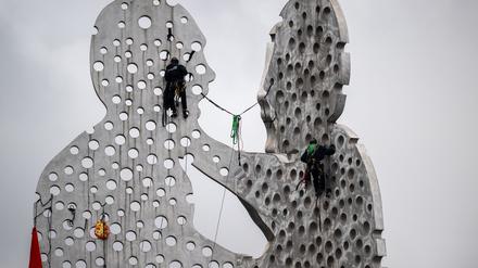 Aktivisten klettern auf Skulptur in der Spree