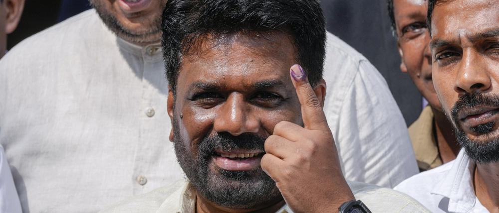 Der srilankische Präsident Anura Kumara Dissanayake zeigt seinen Finger, als er nach der Stimmabgabe bei den Parlamentswahlen das Gebäude verlässt.