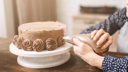 Junge Frau verziert Torte (Symbolbild).