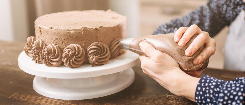 Junge Frau verziert Torte (Symbolbild).
