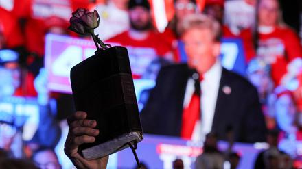Ein Trump-Unterstützer hält bei einer Wahlkampfveranstaltung in Michigan eine Bibel und eine Rose hoch. 