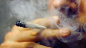 Ein Mann zieht an einem Joint. 