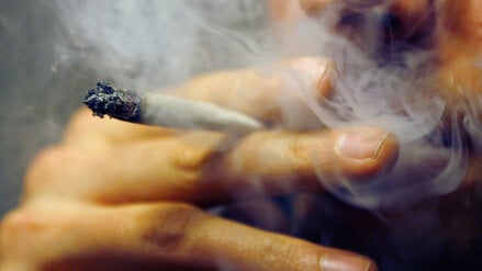 Ein Mann raucht einen Joint.