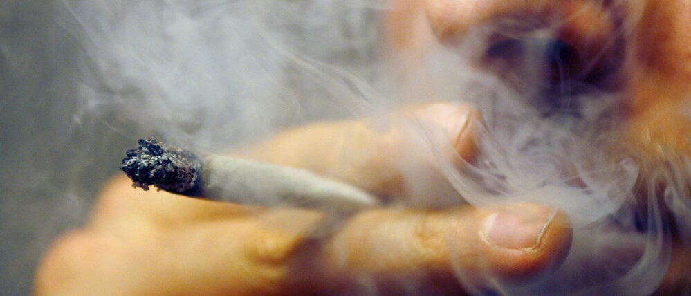 Ein Mann raucht einen Joint.