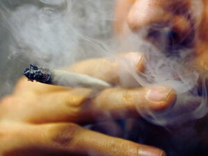 Ein Mann raucht einen Joint.