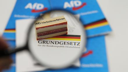 Ein Stempel mit dem Aufdruck AfD-Verbotsverfahren liegt auf dem Grundgesetz der Bundesrepublik Deutschland.