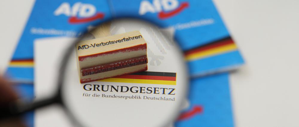 Ein Stempel mit dem Aufdruck AfD-Verbotsverfahren liegt auf dem Grundgesetz der Bundesrepublik Deutschland.