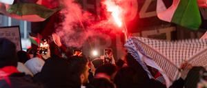 Ein Teilnehmer einer propalästinensischen Demonstration hält eine Bengalische Fackel. Mehrere Hundert Menschen haben für Solidarität mit Palästina demonstriert.