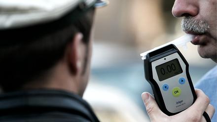 In einer gestellten Szene bläst ein Mann am Freitag (28.12.07) in ein Alkoholtestgerät der Polizei. 