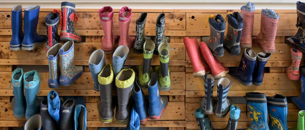 ARCHIV - 13.05.2023, Sachsen-Anhalt, Halle (Saale): Gummistiefel hängen an einer Palettenwand in der Kindertagesstätte Heide-Süd. (zu dpa: «Brombeer-Pläne: Sprachtest vor der Schule für Fünfjährige») Foto: Heiko Rebsch/dpa +++ dpa-Bildfunk +++