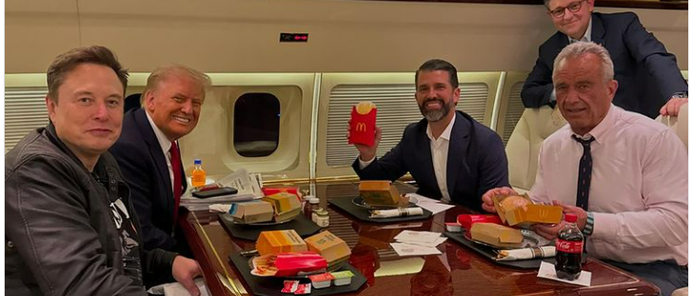 Donald Trump, sein Sohn, Tech-Milliardär Elon Musk und Kennedy im Flugzeug an einem Tisch. 
