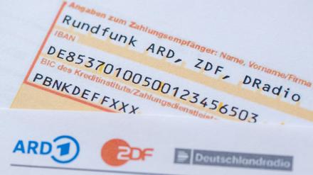 Ein Anschreiben zur Anmeldung für die Rundfunkgebühren liegt auf einem Überweisungsträger. 