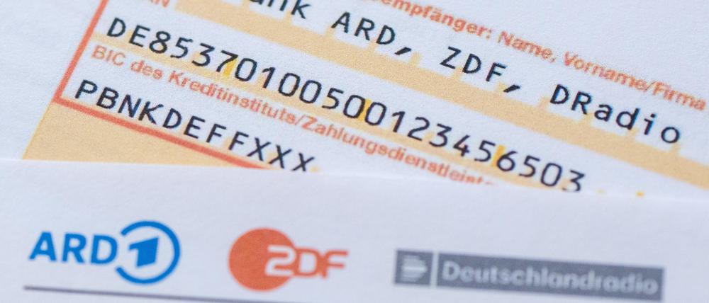 Ein Anschreiben zur Anmeldung für die Rundfunkgebühren liegt auf einem Überweisungsträger. 