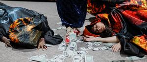Activists lie next to fake currency bills as they participate in a protest action during the United Nations climate change conference COP29 in Baku, Azerbaijan November 20, 2024. REUTERS/Maxim Shemetov
