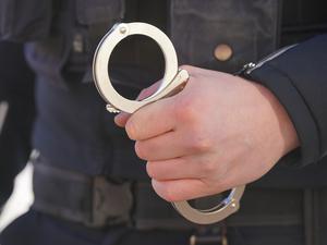 Ein Polizist hält Handschellen in der Hand. 