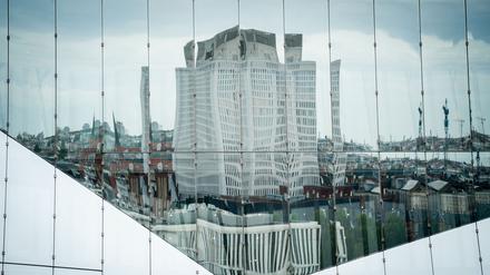 Die Universitätsklinik Charité mit dem Bettenhaus spiegelt sich in einer Bürohausfassade in Berlin-Mitte.