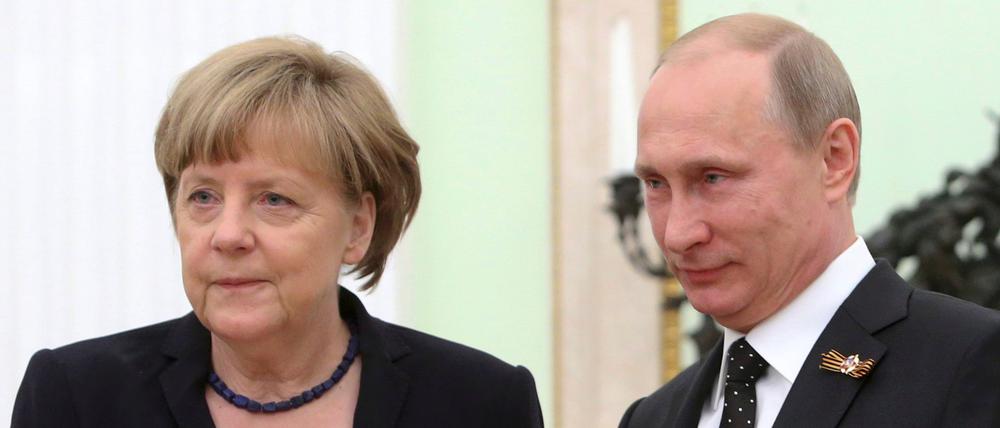 Der russische Präsident Wladimir Putin schüttelt die Hand der damaligen Bundeskanzlerin Angela Merkel während eines Treffens im Kreml (Archivbild).