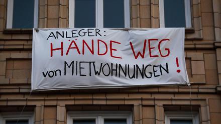 „HÄNDE WEG von MIETWOHNUNGEN!“ – Protesttransparente an den Fassaden einiger Häuser in der Karl-Marx-Alllee in Berlin, Deutschland.