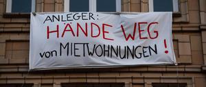 „HÄNDE WEG von MIETWOHNUNGEN!“ – Protesttransparente an den Fassaden einiger Häuser in der Karl-Marx-Alllee in Berlin, Deutschland.