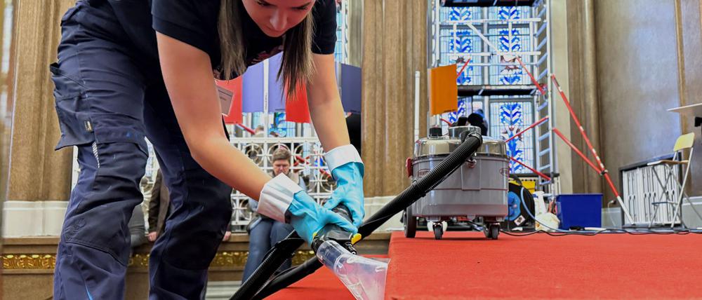Elena Stamatiou (20) aus Hessen reinigt den roten Teppich im Treppenbereich des Roten Rathauses.