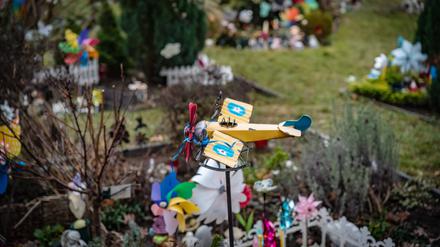 Auf einem Friedhof in Reinickendorf ist ein Spielzeugflugzeug über einem der Gräber für Sternenkinder angebracht.