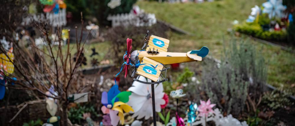 Auf einem Friedhof in Reinickendorf ist ein Spielzeugflugzeug über einem der Gräber für Sternenkinder angebracht.