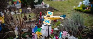 Auf einem Friedhof in Reinickendorf ist ein Spielzeugflugzeug über einem der Gräber für Sternenkinder angebracht.