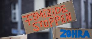 Bei einer Demonstration gegen Gewalt an Frauen hält eine Teilnehmerin ein Plakat mit der Aufschrift „Femizide stoppen“ (Symbolbild).
