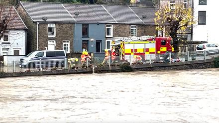 Feuerwehrleute lassen Wasser in einen angeschwollenen Fluss, während der Sturm „Bert“ über Großbritannien hinwegfegt.