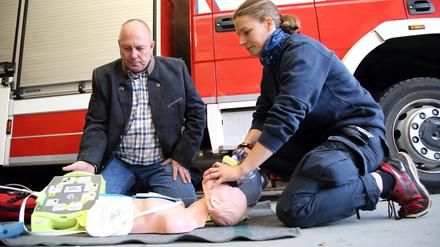 Andreas Spora, von der Jochum Medizintechnik GmbH Berlin, sowie Anästhesistin und Feuerwehrfrau Marie-C. Schumann bei einer Vorführung im Rahmen der Spendenübergabe eines AED (Automatisch Externer Defibrillator) Trainingsgerät mit Trainingspuppe an den Förderverein Freiwillige Feuerwehr Potsdam OT Groß Glienicke im Feuerwehrhaus Groß Glienicke.
