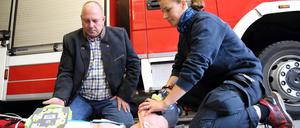 Andreas Spora, von der Jochum Medizintechnik GmbH Berlin, sowie Anästhesistin und Feuerwehrfrau Marie-C. Schumann bei einer Vorführung im Rahmen der Spendenübergabe eines AED (Automatisch Externer Defibrillator) Trainingsgerät mit Trainingspuppe an den Förderverein Freiwillige Feuerwehr Potsdam OT Groß Glienicke im Feuerwehrhaus Groß Glienicke.