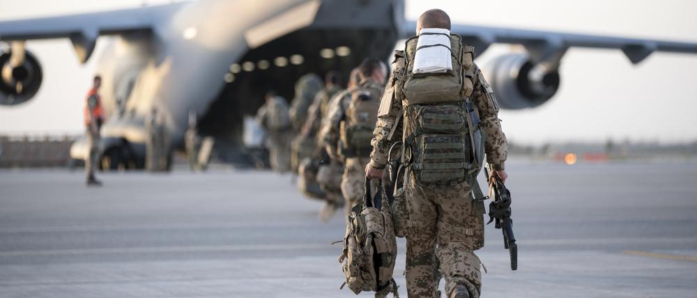 Symbolbild. Soldaten der Bundeswehr laufen in Afhganistan auf einen Militärtransporter C17 zu.