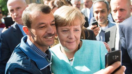 Anfang September 2015, Flüchtlingsunterkunft in Berlin-Spandau: Bundeskanzlerin Angela Merkel macht ein Selfie mit einem irakischen Jesiden.