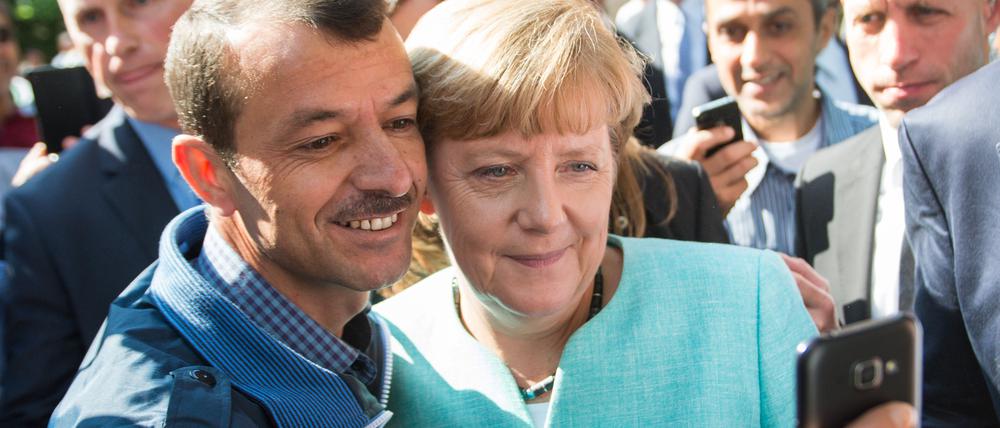 Anfang September 2015, Flüchtlingsunterkunft in Berlin-Spandau: Bundeskanzlerin Angela Merkel macht ein Selfie mit einem irakischen Jesiden.