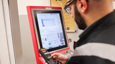 Ein Auszubildender aus Syrien arbeitet bei den Stadtwerken Flensburg in der Ausbildungswerkstatt an einer CNC-Fräse. 