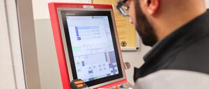 Ein Auszubildender aus Syrien arbeitet bei den Stadtwerken Flensburg in der Ausbildungswerkstatt an einer CNC-Fräse. 