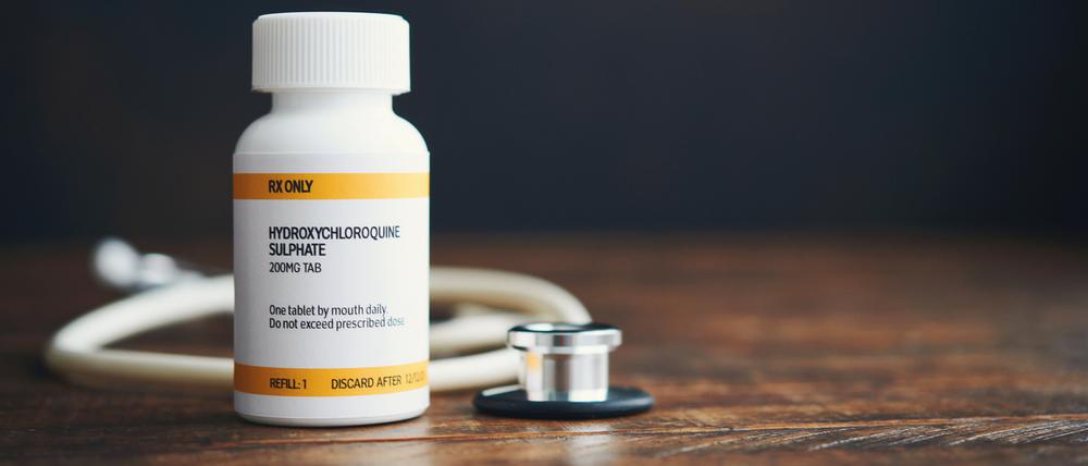Stethoskop mit verschreibungspflichtigen Medikamenten in Pillenflasche: Hydroxychloroquinphosphat.
