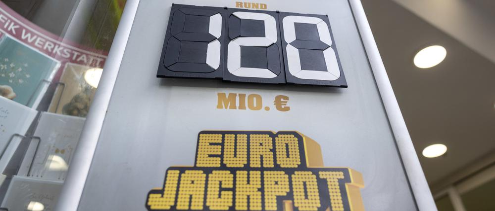 21.11.2024, Nordrhein-Westfalen, Köln: „120 Millionen Euro im Eurojackpot“ steht auf einer Tafel vor einer Lotto-Annahmestelle.