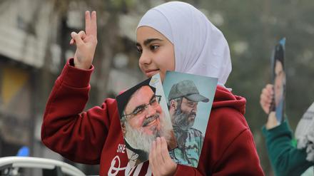 Ein Mädchen in Beirut hält Porträts der getöteten Hisbollah-Führer Hassan Nasrallah und Imad Mughniyeh hoch.