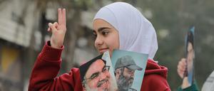 Ein Mädchen in Beirut hält Porträts der getöteten Hisbollah-Führer Hassan Nasrallah und Imad Mughniyeh hoch.
