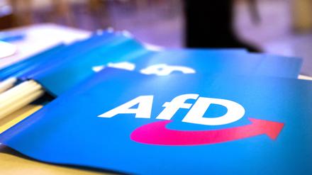 Fähnchen mit dem Logo der AfD liegen auf einem Tisch. 