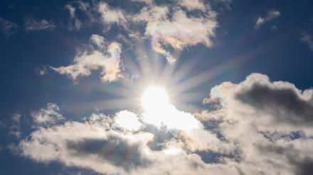 Die Sonne scheint zwischen Wolken hindurch (Symbolbild).