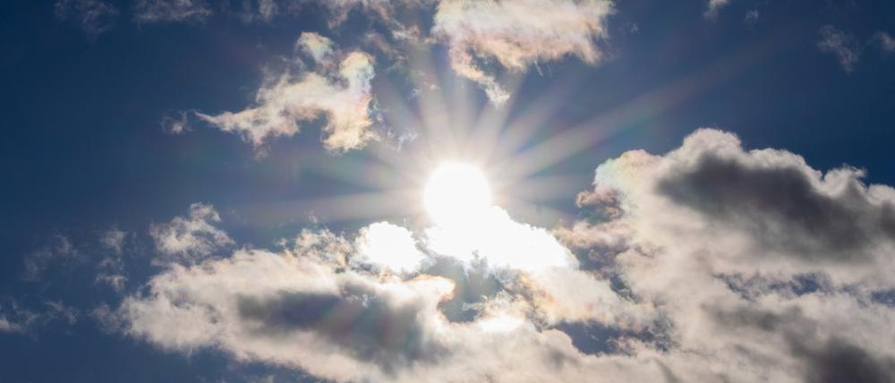 Die Sonne scheint zwischen Wolken hindurch (Symbolbild).