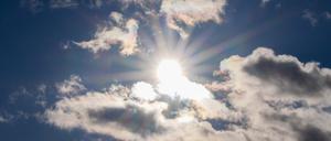 Die Sonne scheint zwischen Wolken hindurch (Symbolbild).