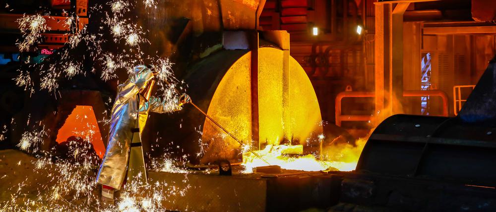 Thyssen-Krupp Steel: Ein Stahlarbeiter im Schutzanzug entnimmt eine 1500 Grad heiße Roheisenprobe beim Abstich am Hochofen 8.